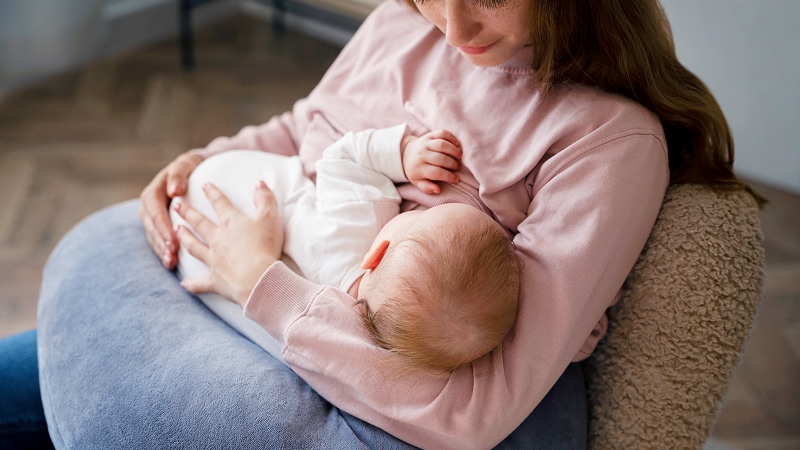 женщина кормит младенца