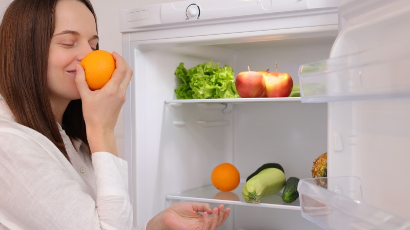 женщина нюхает фрукты