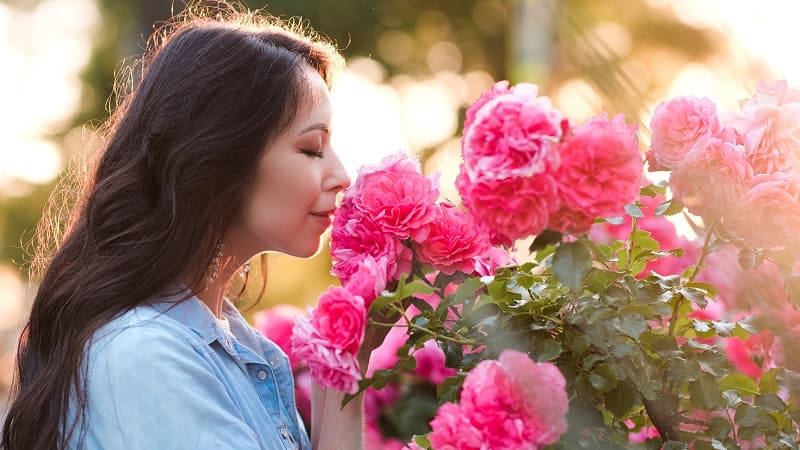 женщина нюхает цветы